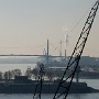 Im Vordergrund ein Kran des Altonaer Fischreihafens.  Dahinter liegt der Köhlbrand und die Köhlbrandbrücke im Geflimmer warmer Luft. Obwohl erst Mitte März war die Temeratur um 20 Grad C und die Luft leider sehr diesig.